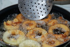 Freír los aros de cebolla en aceite caliente Freír los aros de cebolla en aceite caliente